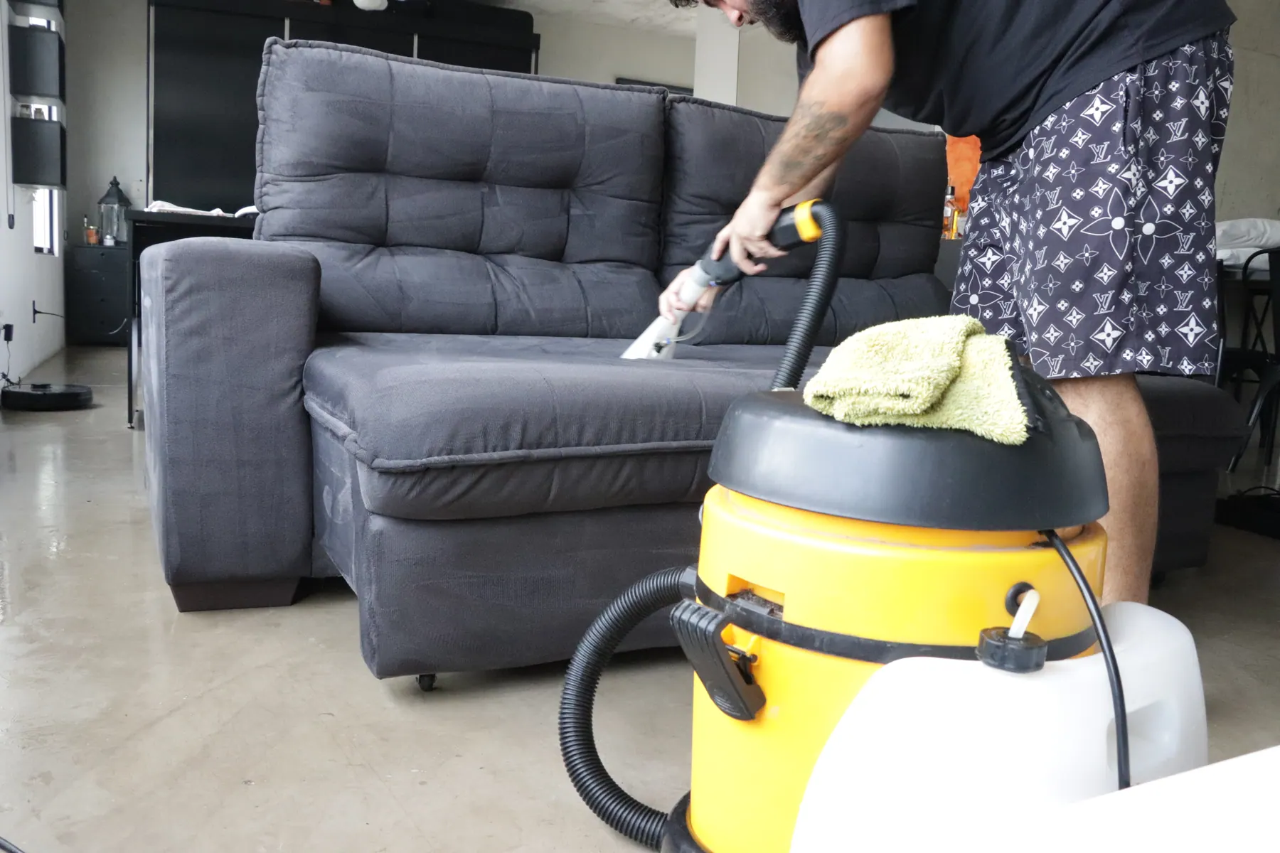 Aplicação de produto em encosto de sofá para higienização profunda.