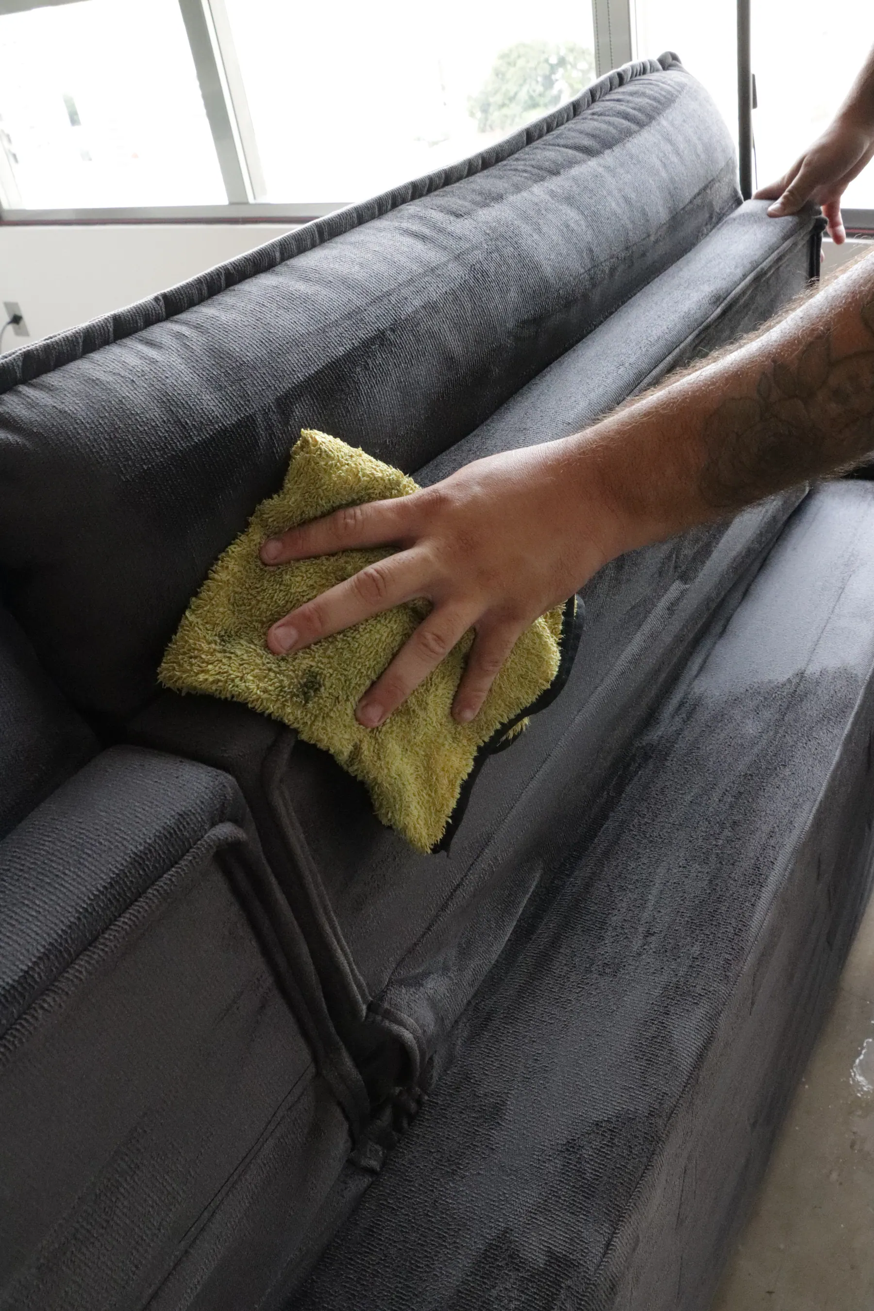 Limpeza de áreas de difícil acesso no estofado durante o atendimento em domicílio.